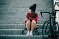 Problem teenager sitting consulting his phone, travels with bicycle