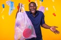 Problem of trash, plastic recycling, pollution and environmental concept - funny man carrying garbage bag on yellow Royalty Free Stock Photo