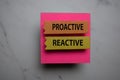 Procative Vs Reactive write on sticky note isolated on Office Desk