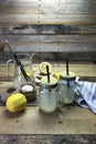 Proccess of making detox water with lemon in a glass jar with a handle, lid, and straw Royalty Free Stock Photo