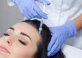 Procedure of mesotherapy. The doctor cosmetologist makes the procedure of mesotherapy in woman`s head.