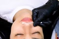 Before the procedure of permanent lip makeup, the master wipes the markings with a cotton swab
