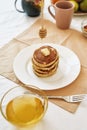 The process of adding honey on top of stack of sweet tasty pancakes on a plate, Process of preparing breakfast on the