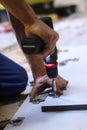 Process of apartment renovation. drilling holes in furniture by fettler. sawdust scatter. unrecognizable men. remodeling, doing Royalty Free Stock Photo