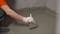 The process of applying mortar - waterproofing to a concrete floor. The concept of waterproofing the floor with a brush Royalty Free Stock Photo