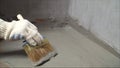 The process of applying mortar - waterproofing to a concrete floor. The concept of waterproofing the floor with a brush Royalty Free Stock Photo
