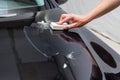 The process of applying a nano-ceramic coating on the car`s hood by a male worker with a sponge and special chemical composition