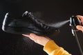 The process of applying a water-repellent spray to black men& x27;s leather demi-season shoes Royalty Free Stock Photo