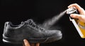 The process of applying a water-repellent spray to black men& x27;s nubuck demi-season shoes Royalty Free Stock Photo