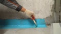 Close-up of a hand applying waterproofing in the bathroom. The process of applying waterproofing mortar to the floor Royalty Free Stock Photo