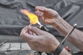 Process of artistic glass processing by burner flame. Hands of mature glassblower Royalty Free Stock Photo