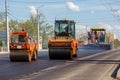 Process of asphalting, asphalt paver machine and two road rollers during road construction works, working on the new Royalty Free Stock Photo