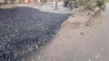 Process of asphalting, blacktopping, and paving, asphalt paver machine and steam roller compactor during construction and repair