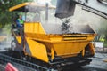Process of asphalting, blacktopping and paving, asphalt paver machine and steam roller compactor during construction and repairing