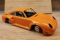 The process of assembling and painting the scale model of the car. Orange sports car in miniature Royalty Free Stock Photo