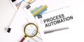 PROCESS AUTOMATION text on white paper on light background with charts paper Royalty Free Stock Photo
