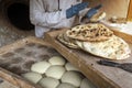 Process of baking bread in a traditional Georgian stove - tone, tandoor. A male cook makes tortillas. The preparation of Royalty Free Stock Photo