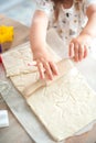 The process of baking from dough. hands roll out the dough and make cookies in the form of asterisks on the dough Royalty Free Stock Photo