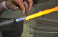 The process of blowing glass bead products. Hand made glass beads in the fire out of red hot glowing glass for bracelets Royalty Free Stock Photo