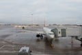 The process of boarding passengers on the plane. Aerodrome. Piles of snow are visible in the distance