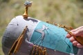 Process of bobbin lace in the shape of a star, hands manage the threads with the help of wooden bobbins to twist them around the