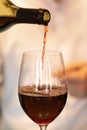 The process of bottling red wine into a glass by a waiter in a restaurant. Royalty Free Stock Photo