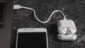 The process of charging white wireless headphones from a laptop.