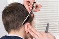 The process of child hair cutting behind the ear with scissors, leveling the length Royalty Free Stock Photo