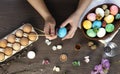 The process of coloring Easter eggs, female hands color eggs, top view.