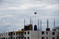 The process of construction. Building materials are delivered to a multi-storey building under construction using a lifting cran