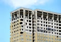 Process of construction high-rise modern apartment building with penthouse over blue sky in sunny day Royalty Free Stock Photo