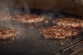 Process of cooking cheeseburgers on the grill. Close up beef meat burgers for hamburger. Royalty Free Stock Photo