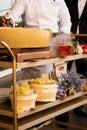 The process of cooking handmade pasta in cheese on a wooden stand with vegetables.Closeup of a professional chef in white uniform. Royalty Free Stock Photo