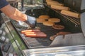 Process of cooking meat for burgers and cheeseburgers, sausages for hot dogs, buns on a grill with burning coals. Royalty Free Stock Photo