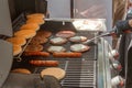 Process of cooking meat for burgers and cheeseburgers, sausages for hot dogs, buns on a grill with burning coals. Royalty Free Stock Photo