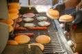 Process of cooking meat for burgers and cheeseburgers, sausages for hot dogs, buns on a grill with burning coals. Royalty Free Stock Photo