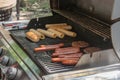 Process of cooking meat for burgers and cheeseburgers, sausages for hot dogs, buns on a grill with burning coals. Royalty Free Stock Photo