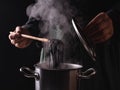 The process of cooking pasta. Black seafood pasta with squid ink in a hot pot with open lid Royalty Free Stock Photo