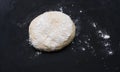 The process of cooking pizza, pies, tarts or buns. Ball of dough on the table. The wooden board covered with flour