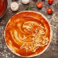 Process of cooking. Unbaked pizza with grated cheese Royalty Free Stock Photo