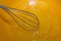 Process of cooking. Whipping egg yolks with a metal whisk.