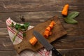 The process of cutting carrots into circles on a cutting board.