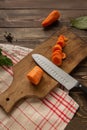 The process of cutting carrots into circles on a cutting board.