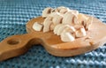 The process of cutting champignon mushrooms on a wooden cutting board