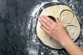 The process of cutting circle from the dough on a dark background. Top views with clear space Royalty Free Stock Photo