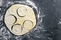 The process of cutting circle from the dough on a dark background. Top views with clear space Royalty Free Stock Photo