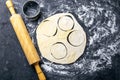 The process of cutting circle from the dough on a dark background. Top views, close-up Royalty Free Stock Photo