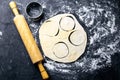 The process of cutting circle from the dough on a dark background. Top views, close-up Royalty Free Stock Photo