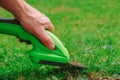 process of cutting grass.Garden equipment and tools. lawn trimmer. electric trimmer in a mans hand cuts the grass. Royalty Free Stock Photo