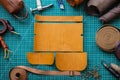 Process cutting scheme of bag with equipment and materials. Male tanner working at leather workshop Royalty Free Stock Photo